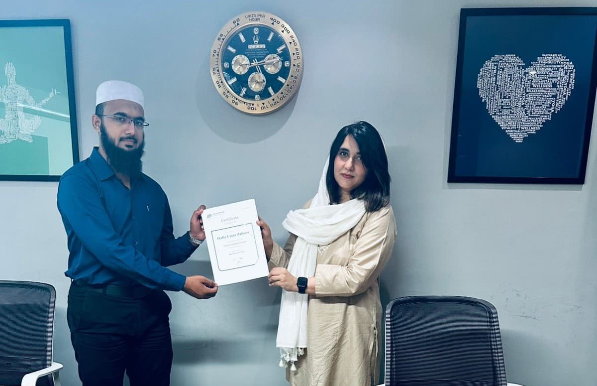 Aisha receiving a professional certificate from a colleague